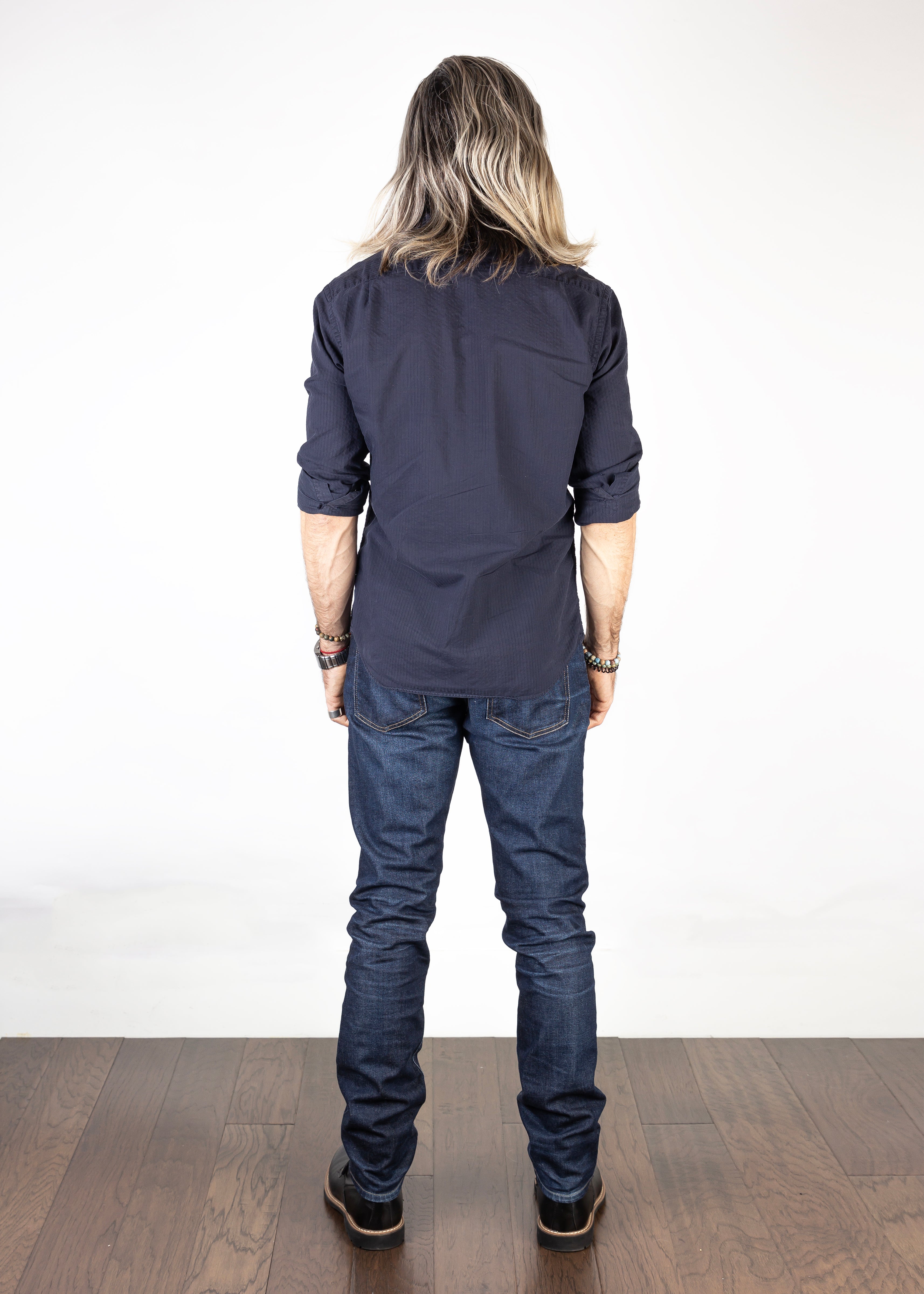 Model wearing the Axe Fuse Slim Straight Comfort Fit Jeans, back-facing, emphasizing their clean lines, slim straight fit, and eco-friendly finish.