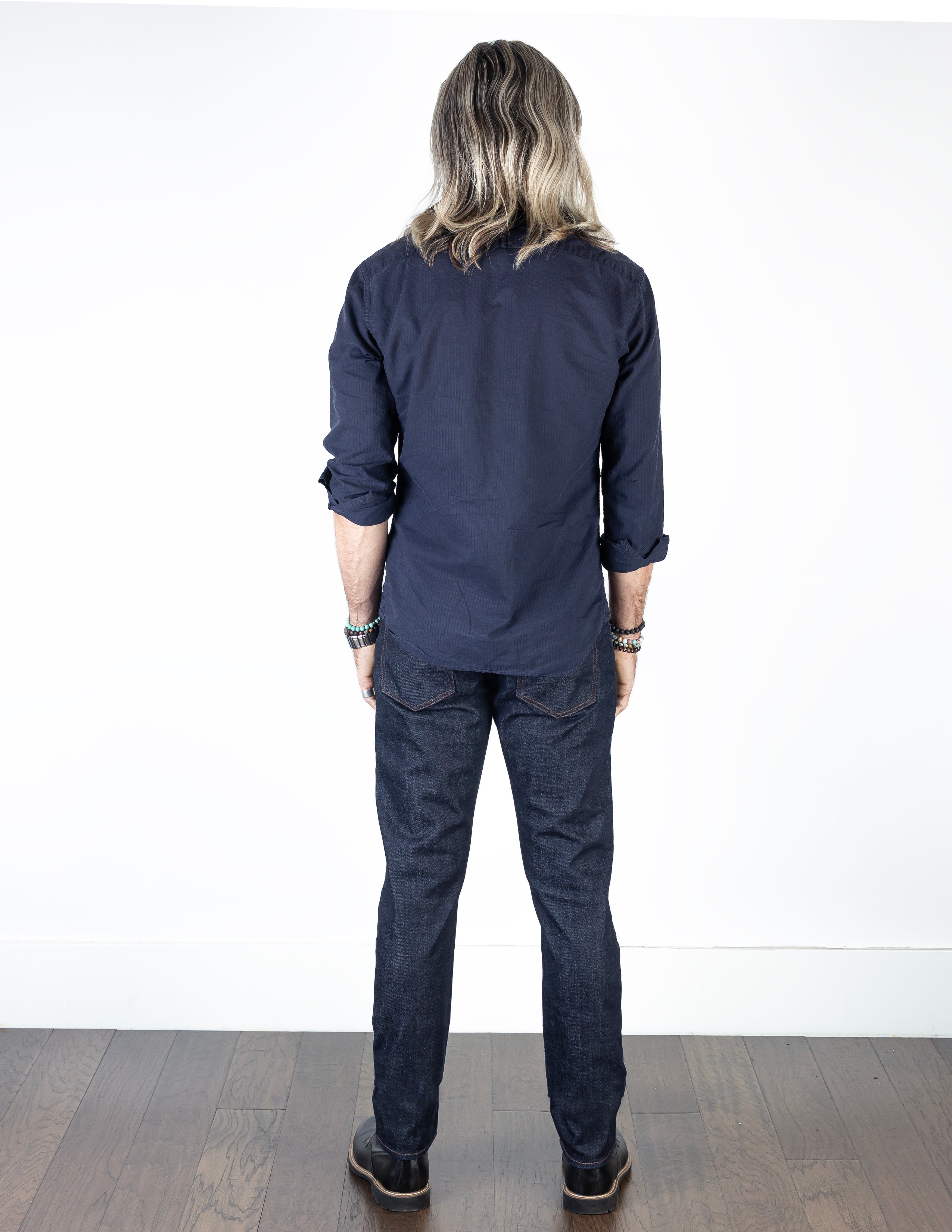 Model wearing the Axe Raw Slim Straight Comfort Fit Jeans, back-facing, showcasing the artisan craftsmanship and durable, eco-friendly Italian denim.