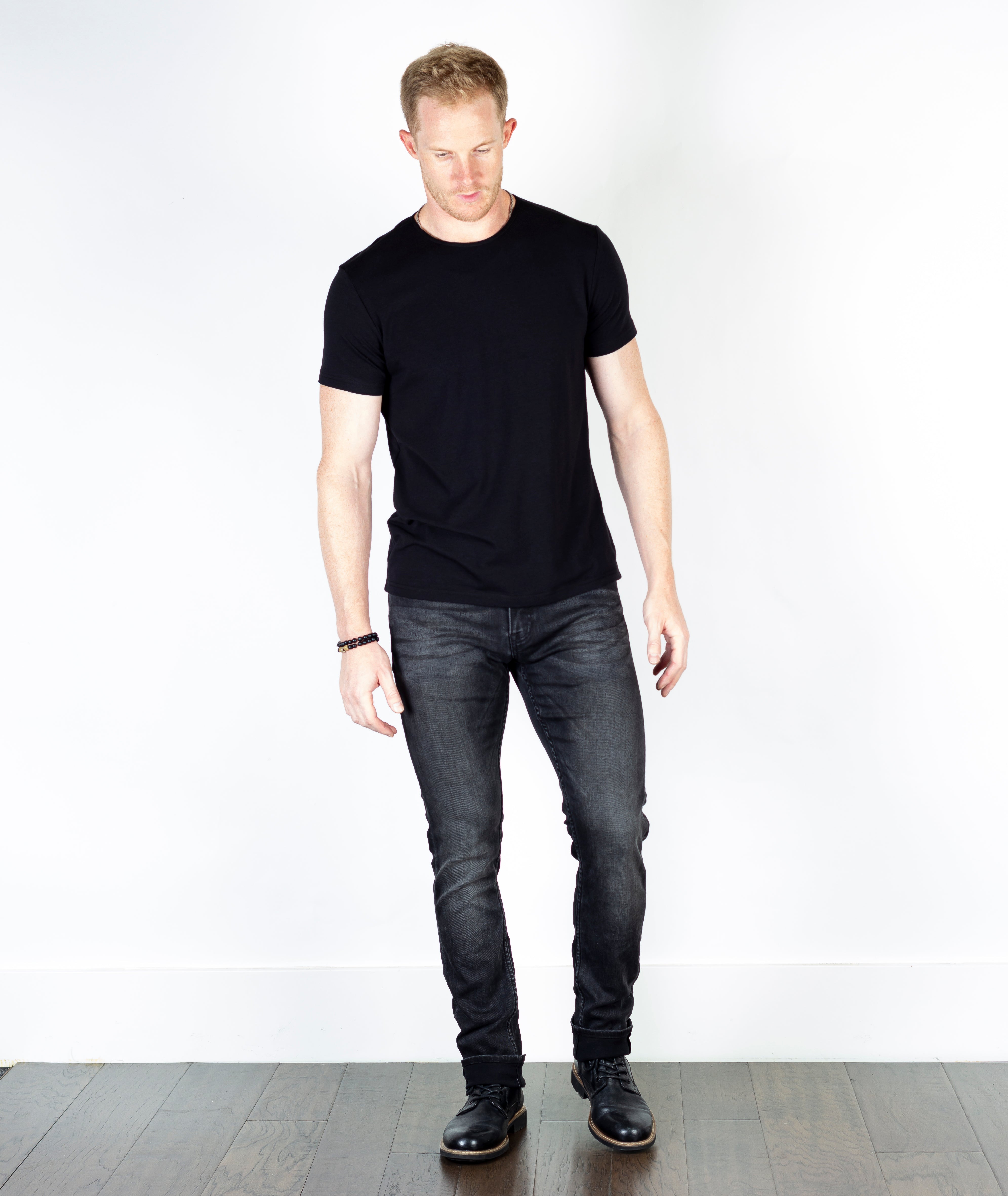 Model wearing Axe Smoke Slim Straight Comfort Fit Jeans, front-facing, showcasing the sleek design and luxurious, soft texture of the denim.