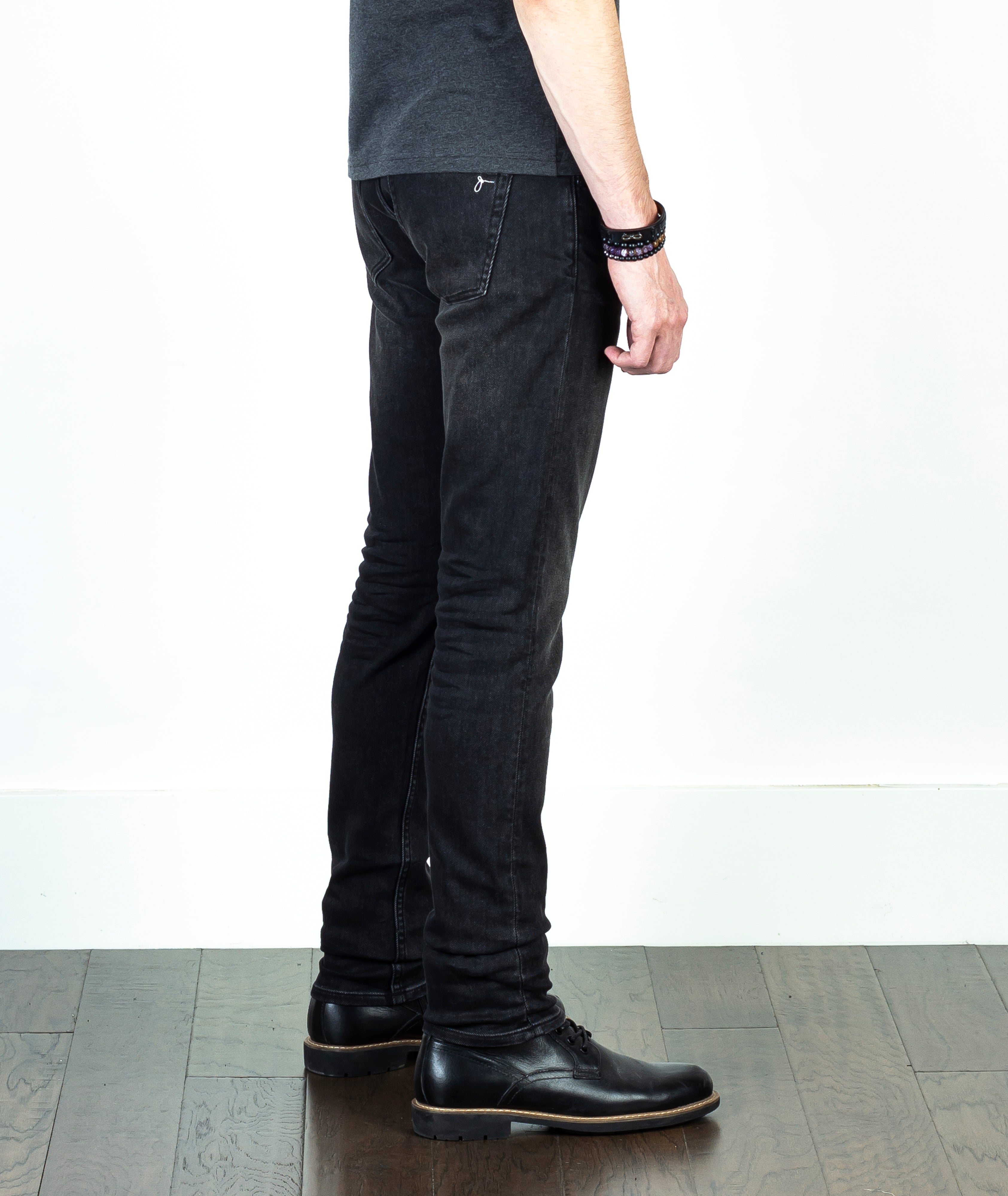 Close-up of a model wearing Axe Smoke Slim Straight Comfort Fit Jeans, side view, emphasizing the luxurious softness and unique denim weave.